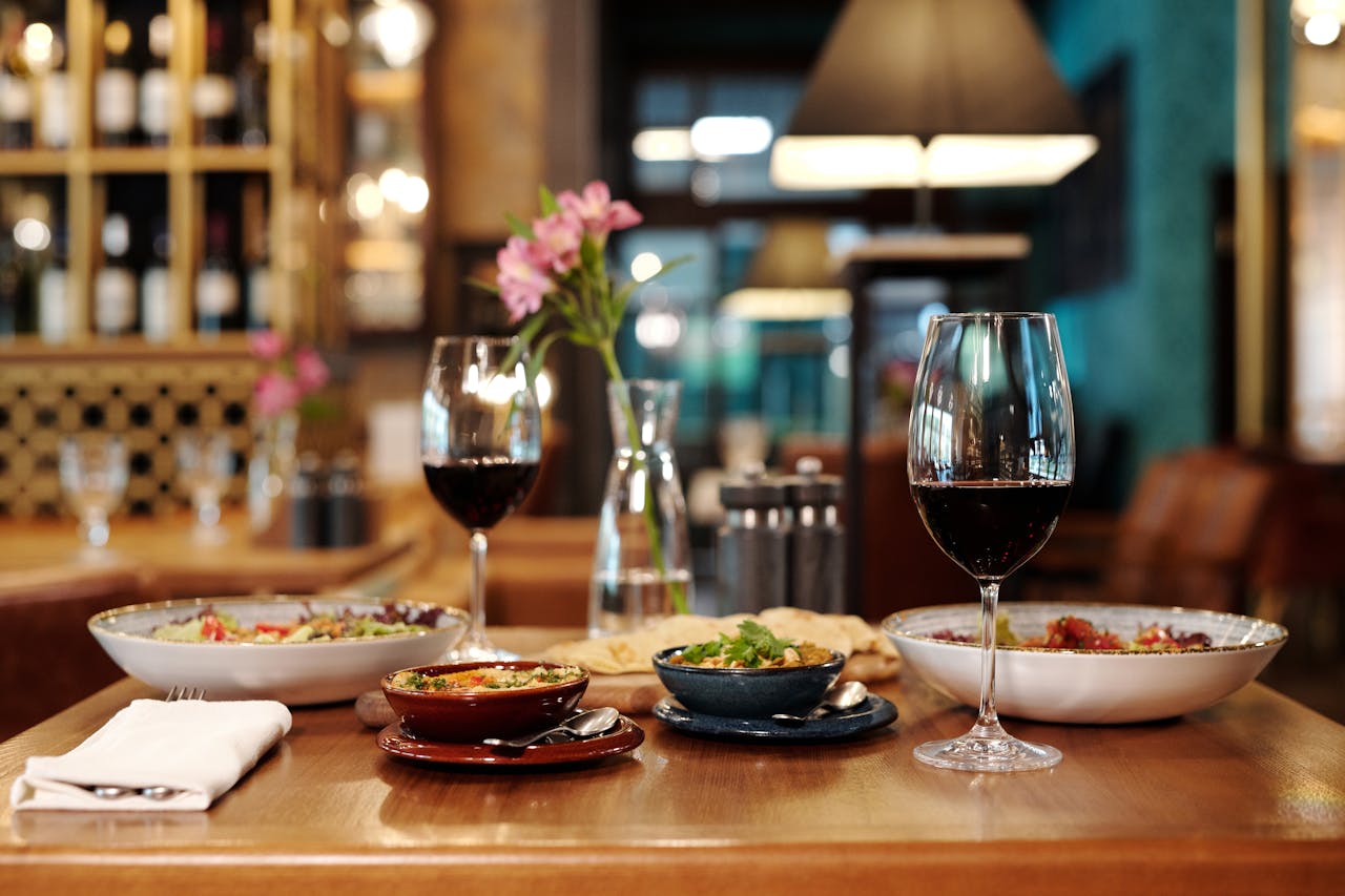 A meticulously arranged restaurant table setting with red wine and various appetizers.
